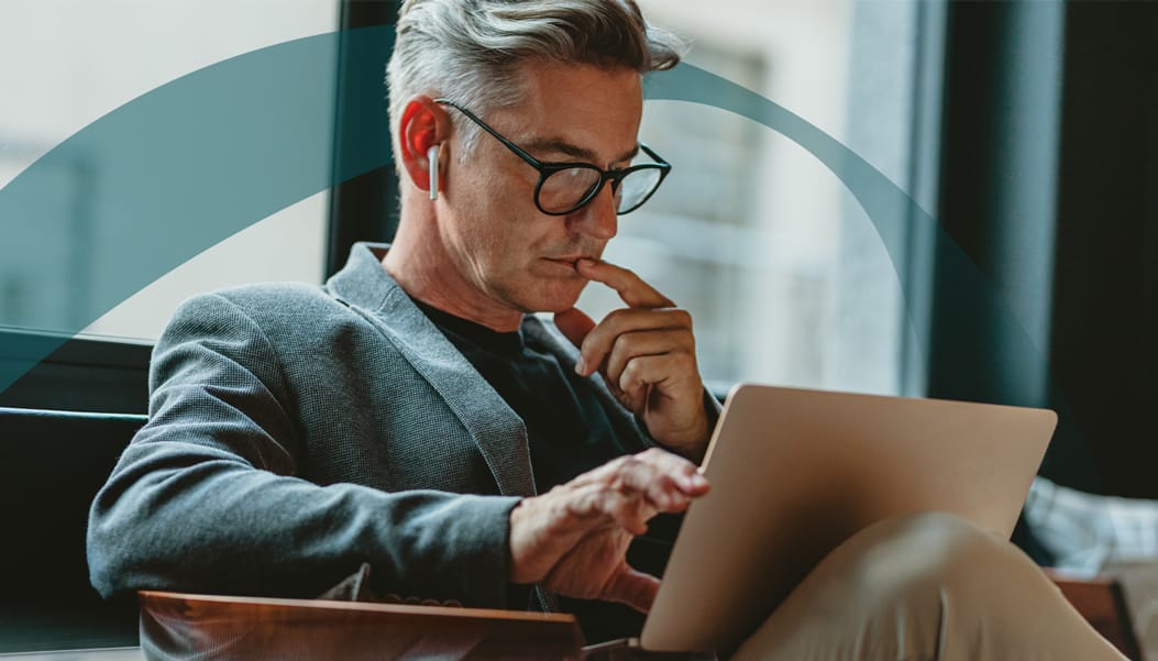 middle-aged man with glasses looking at his computer screen